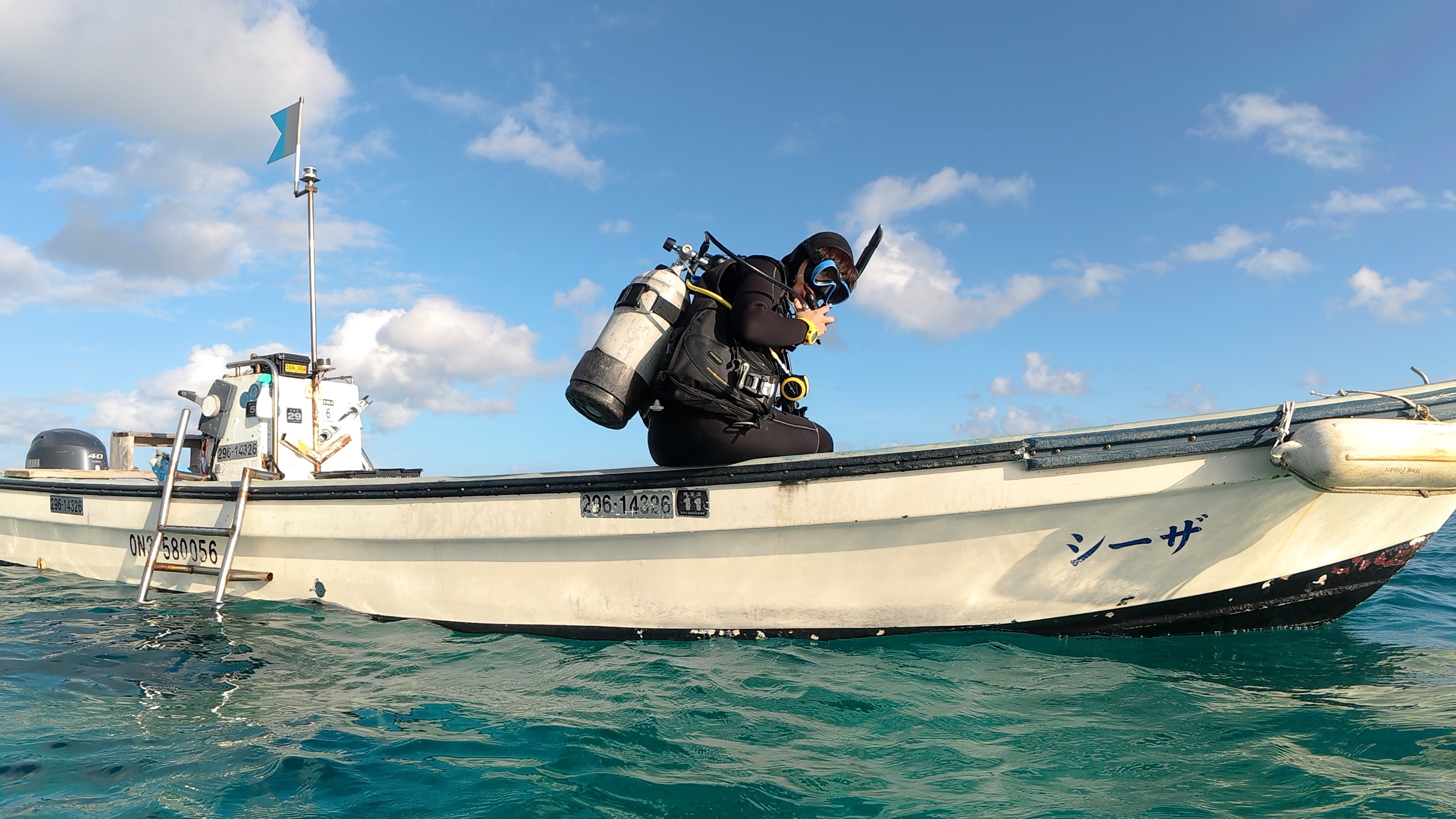 ボートからディープウォーター・エントリーを行い、マスクとレギュレーターを押さえて安全にバックロールエントリーで入水している様子