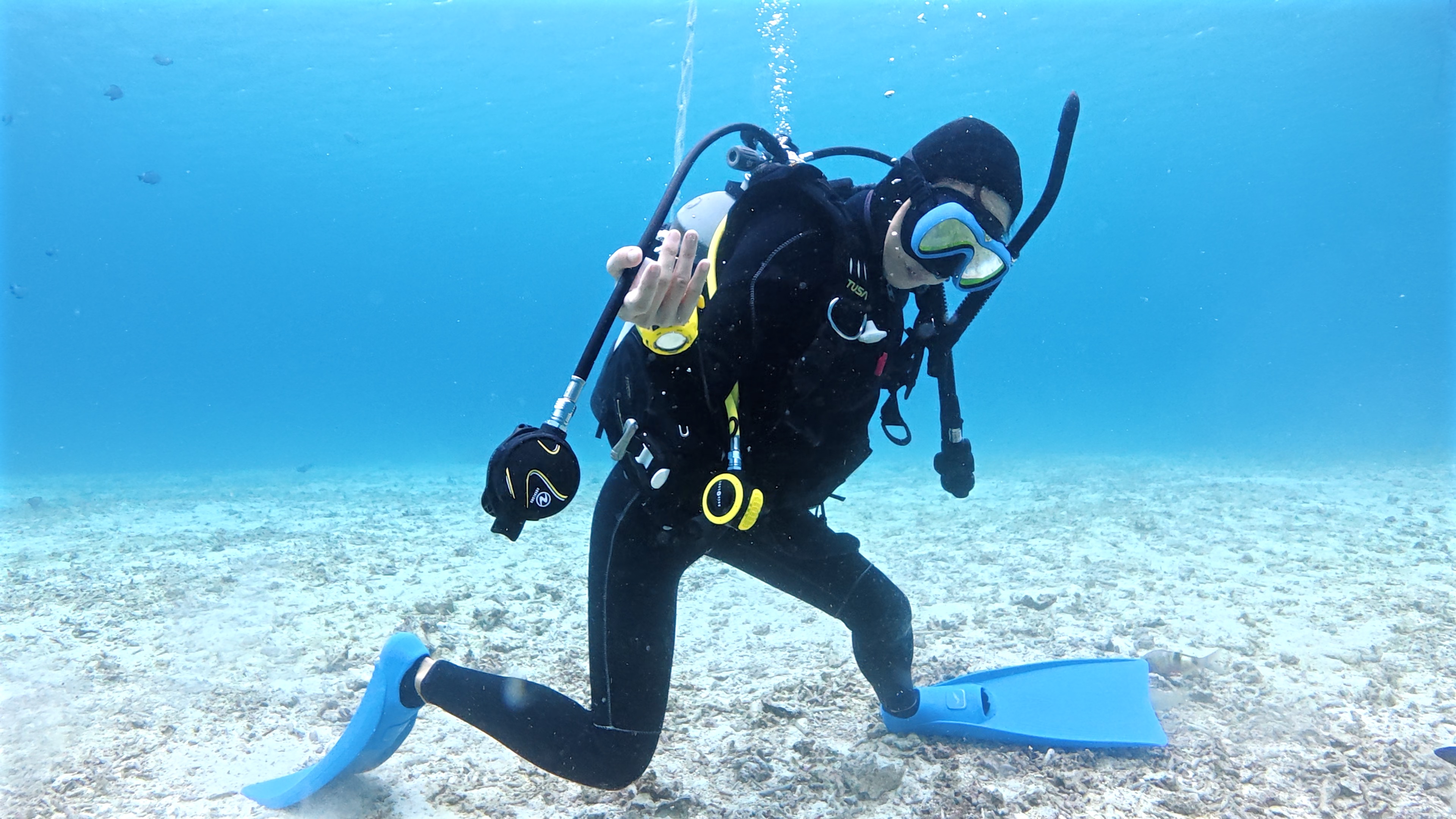 水中で外れたレギュレーターをリカバリーし、口元に戻してクリアを行い呼吸を確保している様子