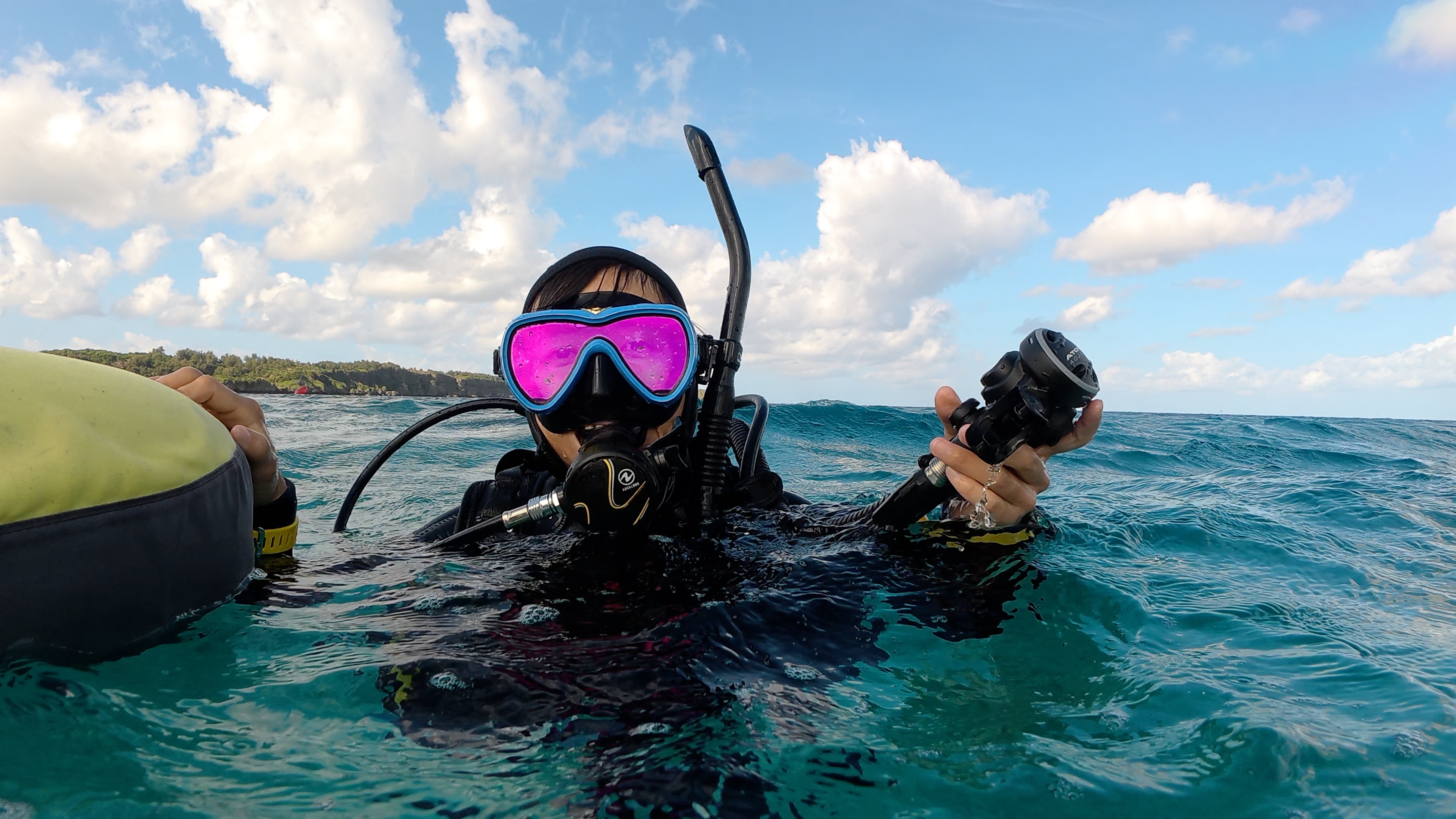 波のある水面で器材を保持し、落ち着いて浮力と呼吸を整えながら待機するダイバー