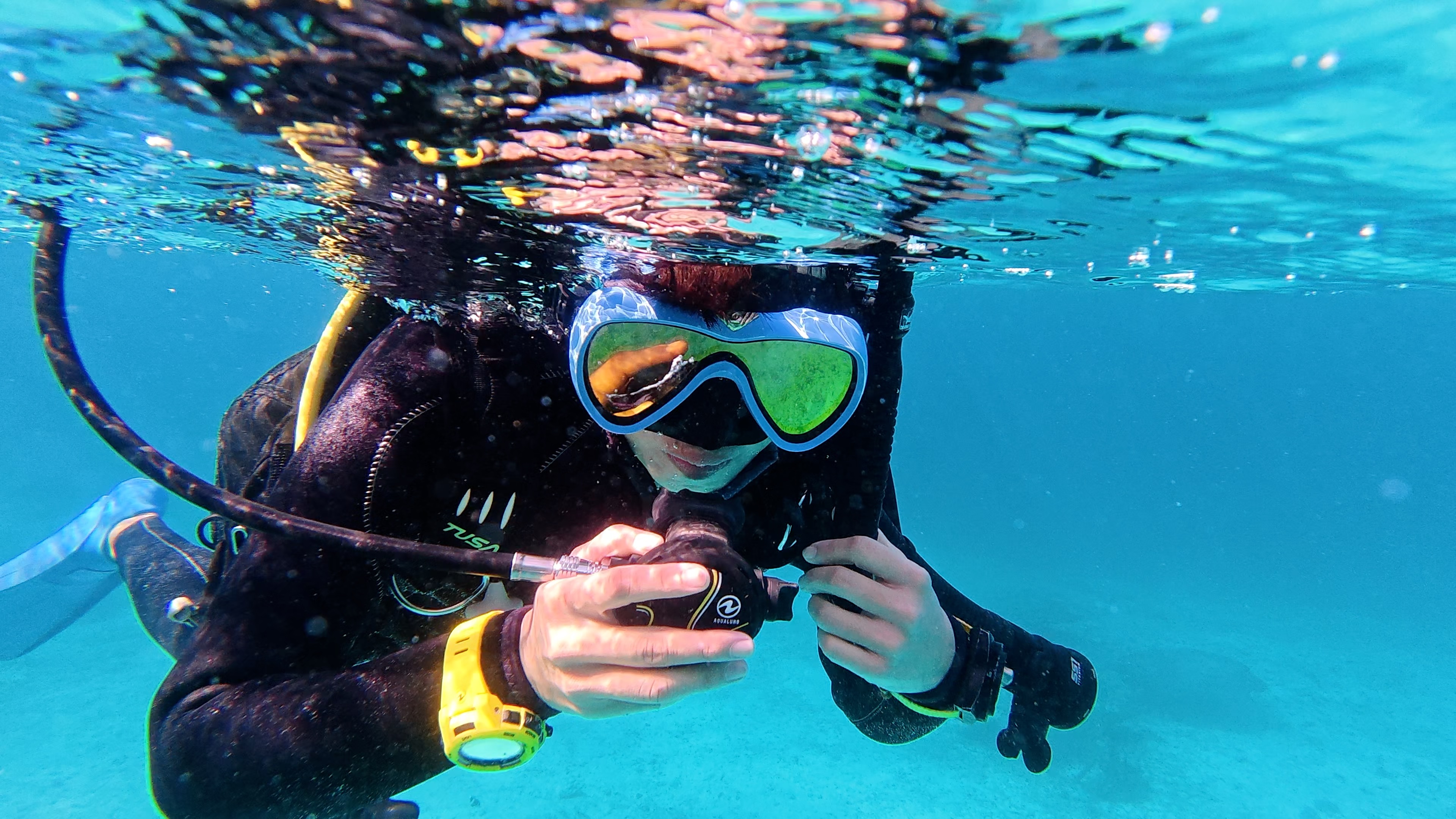 水面でスノーケルからレギュレーターへ、またはレギュレーターからスノーケルへ交換し、呼吸を確保しながら切り替えている様子